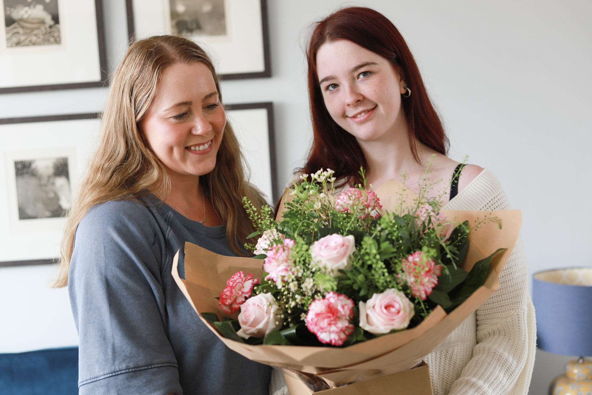 Friend receiving graduation flowers from fellow student